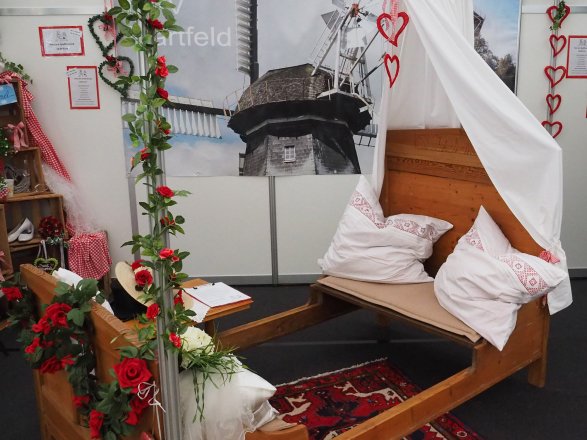 Ein Holzbett dekoriert passend zum Thema Hochzeit