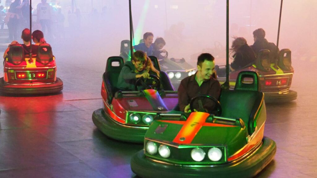 Lachende Menschen sitzen in dem Autoscooter Starlight