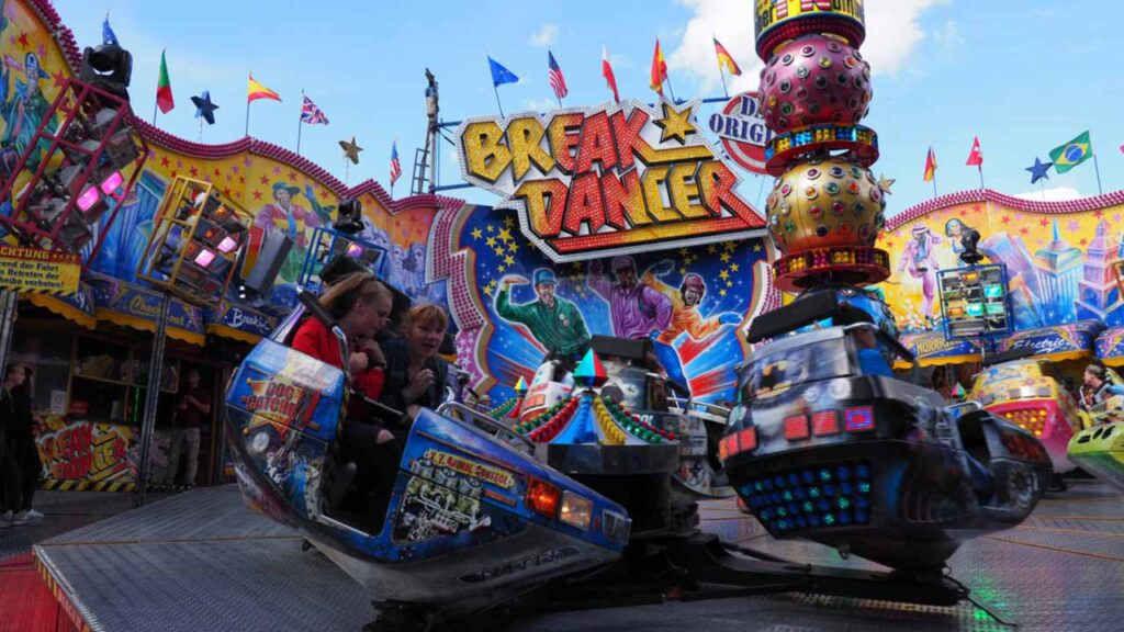 Zwei Mädchen sitzen in einem Abteil des Fahrgeschäfts Breakdancer